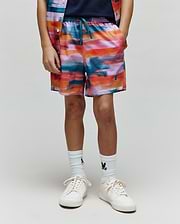Kids Raphael Swim Trunk, relaxed fit, quick-dry fabric. Features a vibrant abstract print in orange, pink, blue, purple, teal, with a small embroidered Psycho Bunny skull logo on the lower left leg.