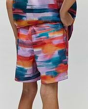 Kids Raphael Swim Trunk, a Psycho Bunny piece, showcasing a vibrant multi-color brushstroke pattern in teal, orange, red, purple, and pink, with a relaxed fit and smooth fabric.
