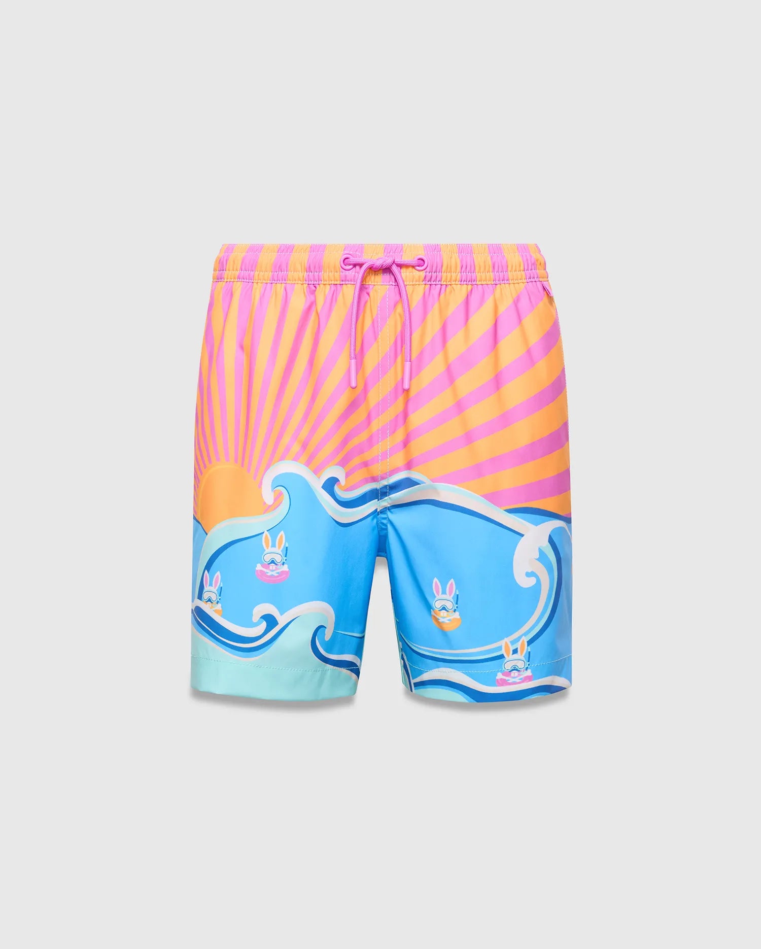 Kids Ray Swim Trunk 6 with a vibrant pink and orange sunburst top, flowing into blue waves featuring small Psycho Bunny skull logos wearing goggles, relaxed fit.