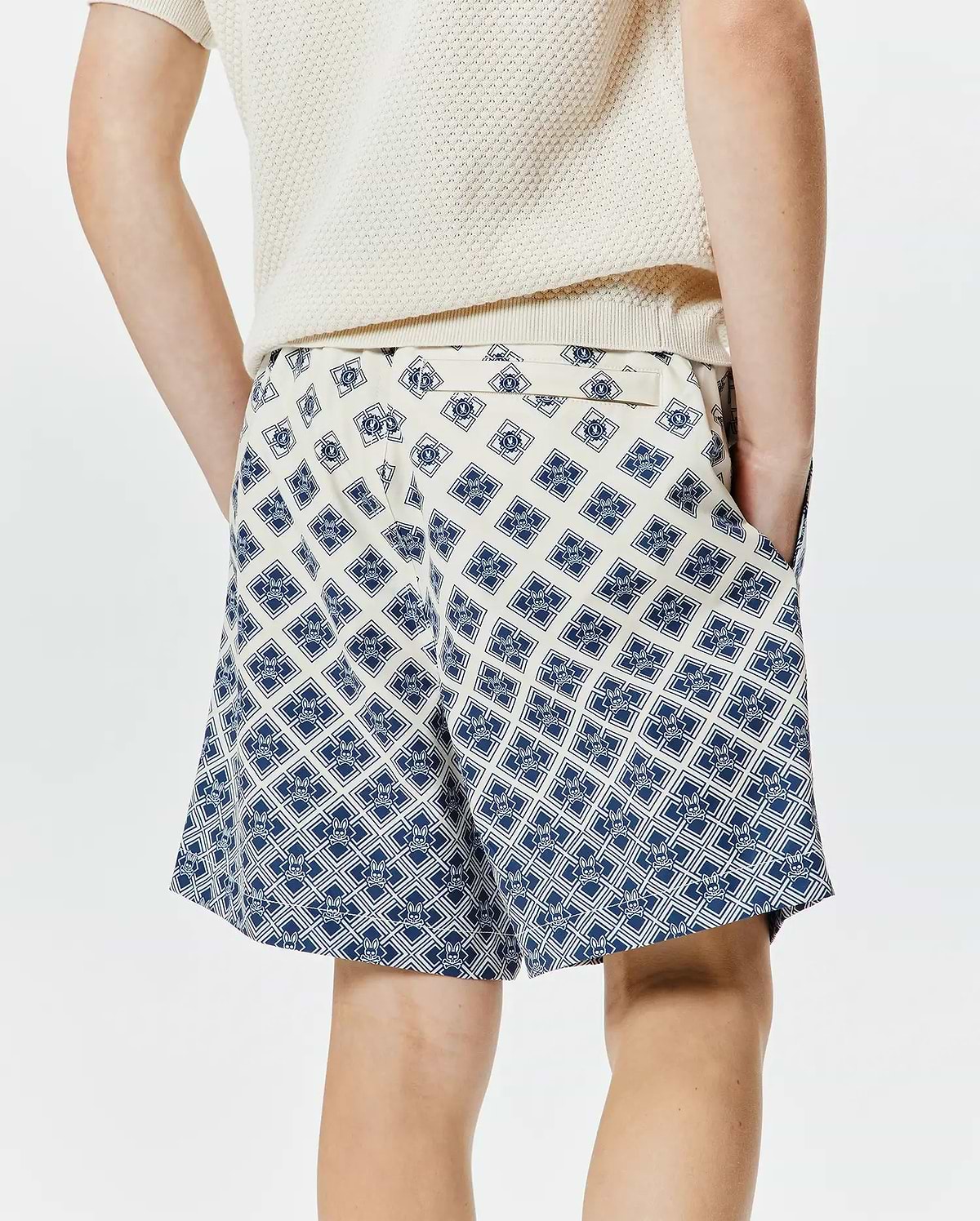 Kids Tobias Swim Trunk, cream with a bold, all-over navy blue geometric pattern featuring the iconic Psycho Bunny skull logo, offering a relaxed fit in smooth, quick-dry fabric. (2)
