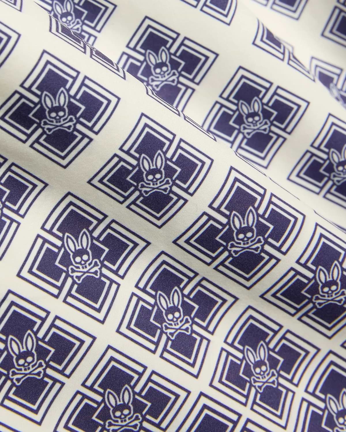 Kids Tobias Swim Trunk in cream with an all-over navy blue geometric square pattern featuring repeated Psycho Bunny skull logos on smooth woven fabric. (6)