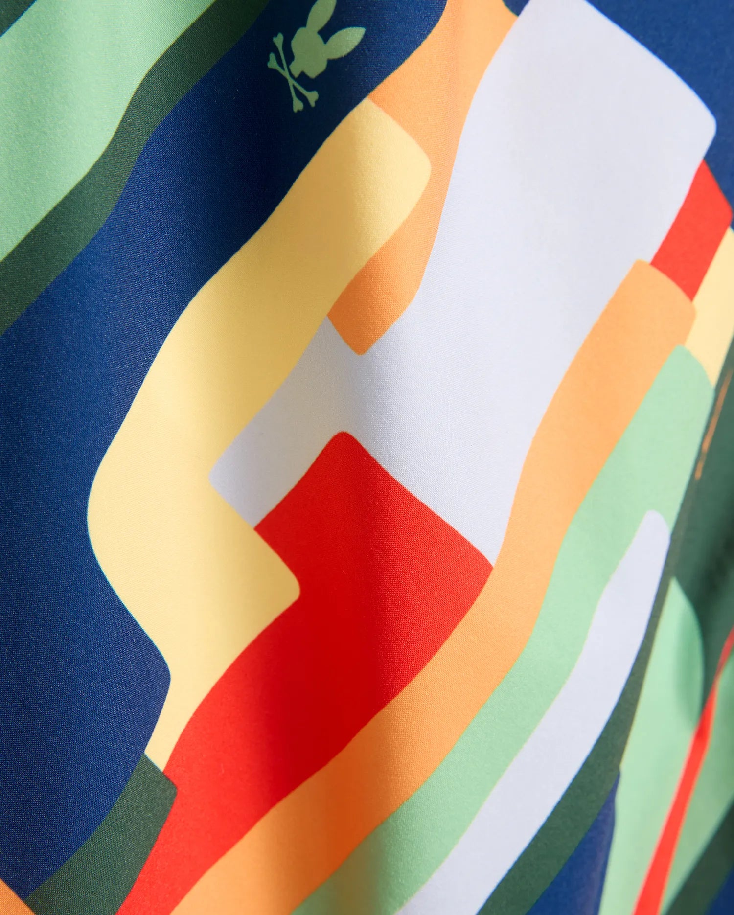 Kids Wes All Over Print Swim Trunk with a vibrant multi-color abstract wavy pattern in blue, green, yellow, orange, red, and white, featuring a small integrated light green Psycho Bunny skull logo.