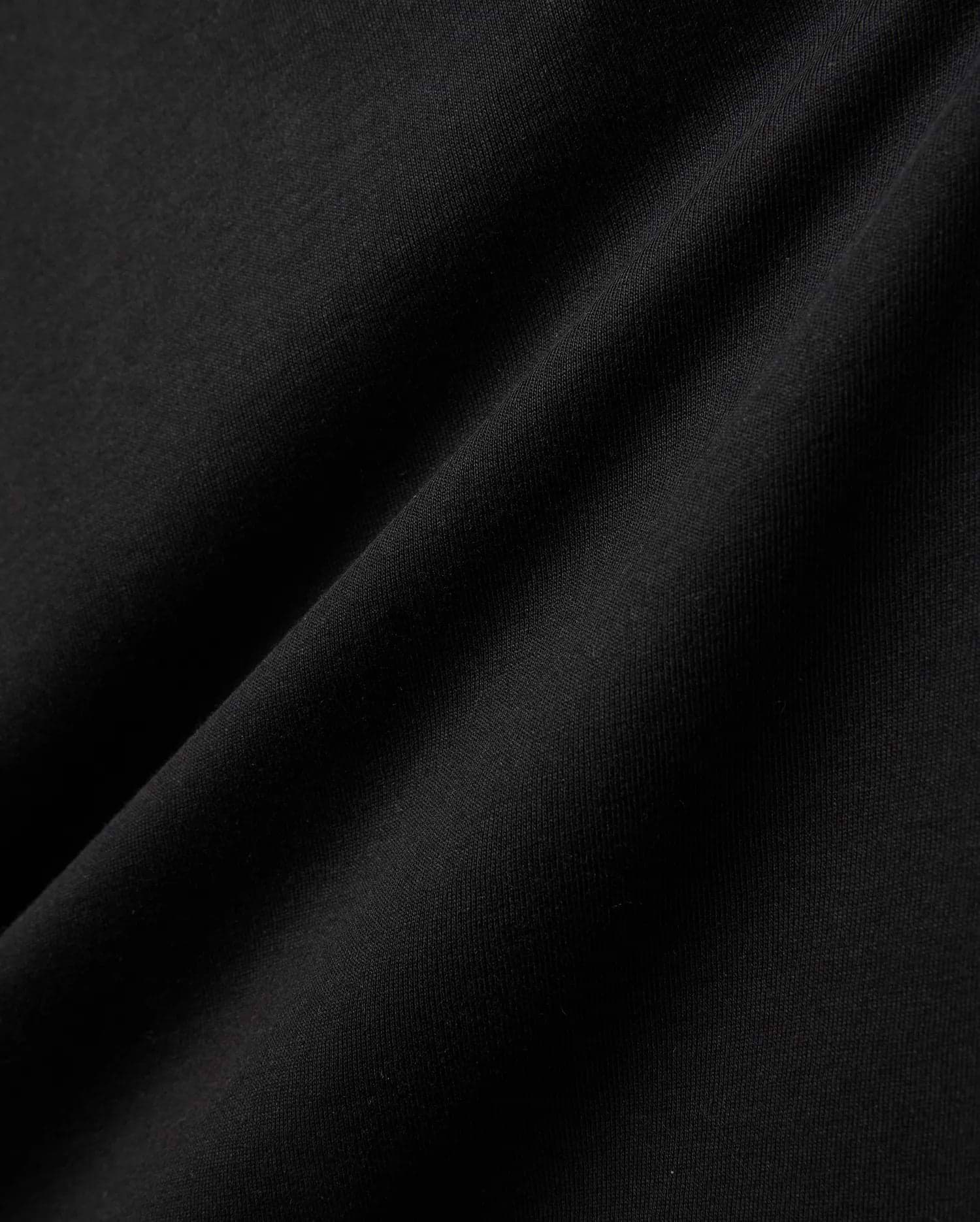 Kids Gordley Mix Media Jacket, a premium Psycho Bunny piece in deep black, showcasing a luxurious, soft-touch jersey knit fabric with subtle texture and elegant draping folds, hinting at refined streetwear style.