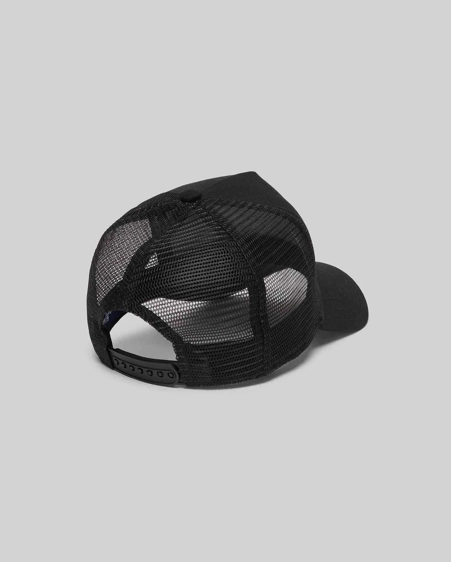 Psycho Bunny Kids Adamo Trucker Cap, a sleek black cap featuring a structured solid front panel and breathable mesh back, complete with an adjustable snapback closure for a custom fit.
