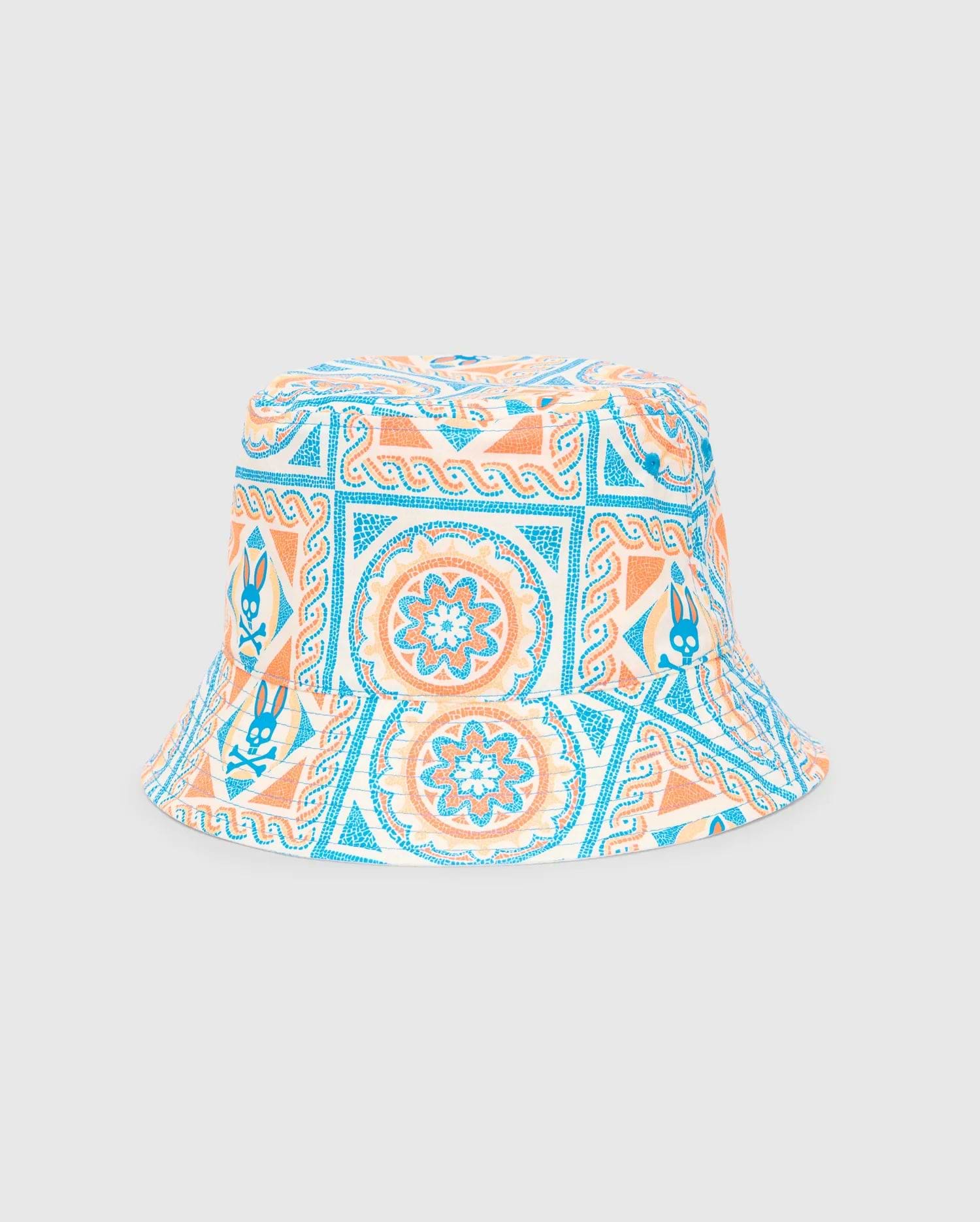 Kids Frank Reversible Bucket Hat in white with an all-over vibrant blue and orange mosaic pattern, featuring repeated small Psycho Bunny skull logos and floral motifs.