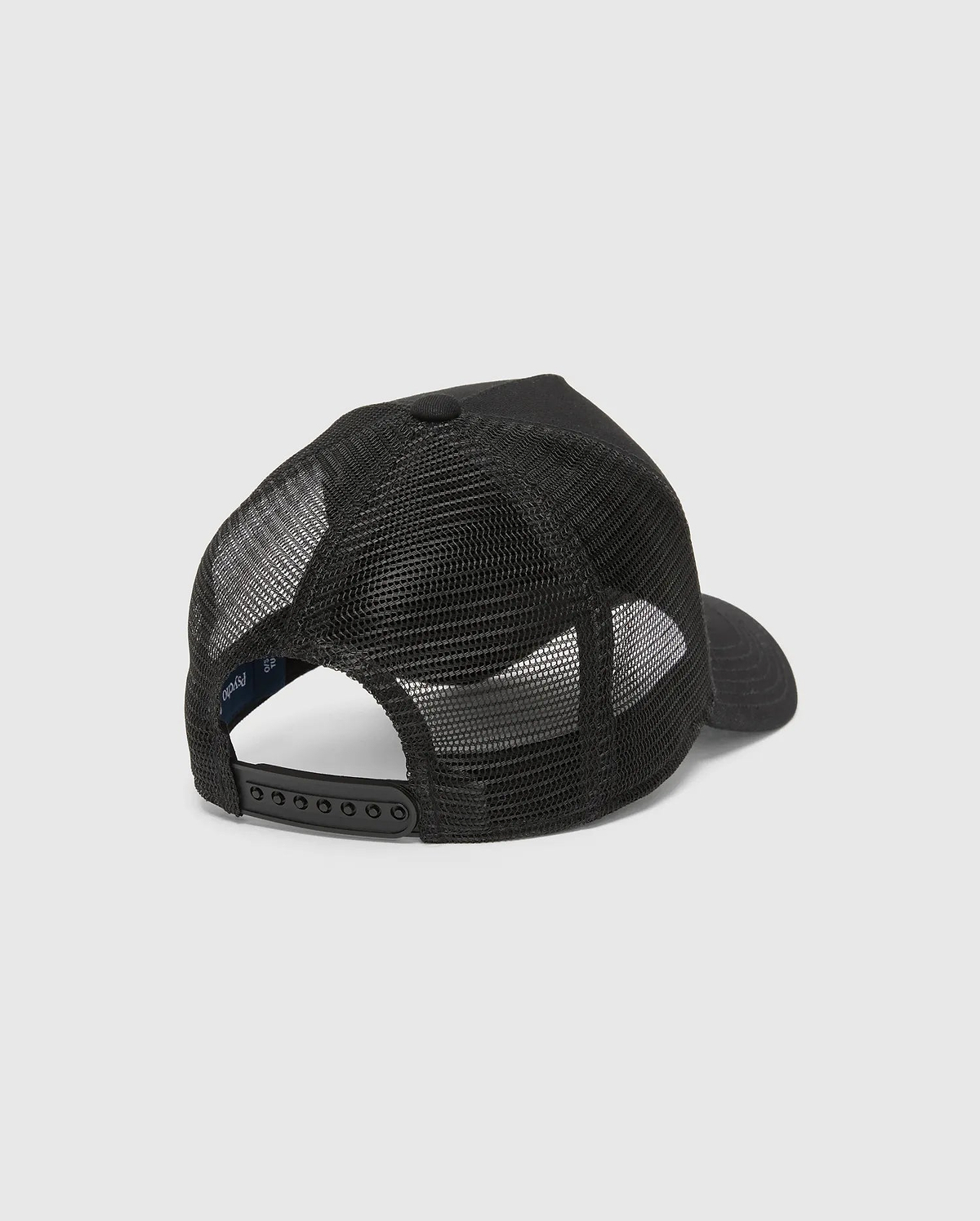 Black Kids Isaac Trucker Cap featuring a breathable mesh back, solid front panel, adjustable snapback closure, and a small inner Psycho Bunny brand tag.