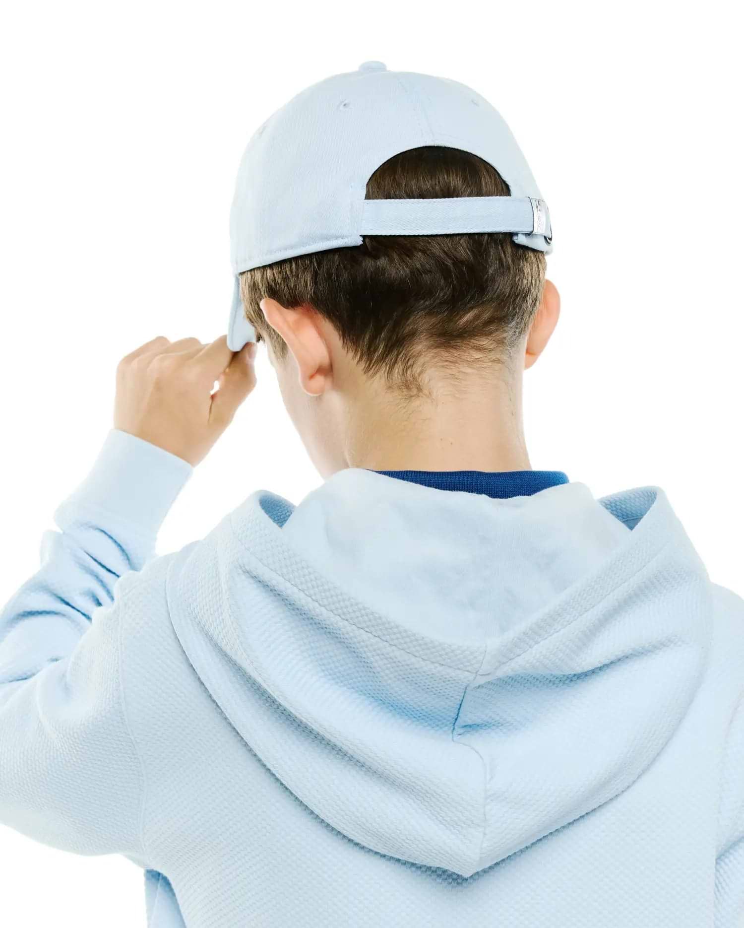 Light blue Kids Jaydon Baseball Cap with adjustable strap and silver buckle, paired with a light blue waffle knit hoodie, revealing a dark blue undershirt collar.