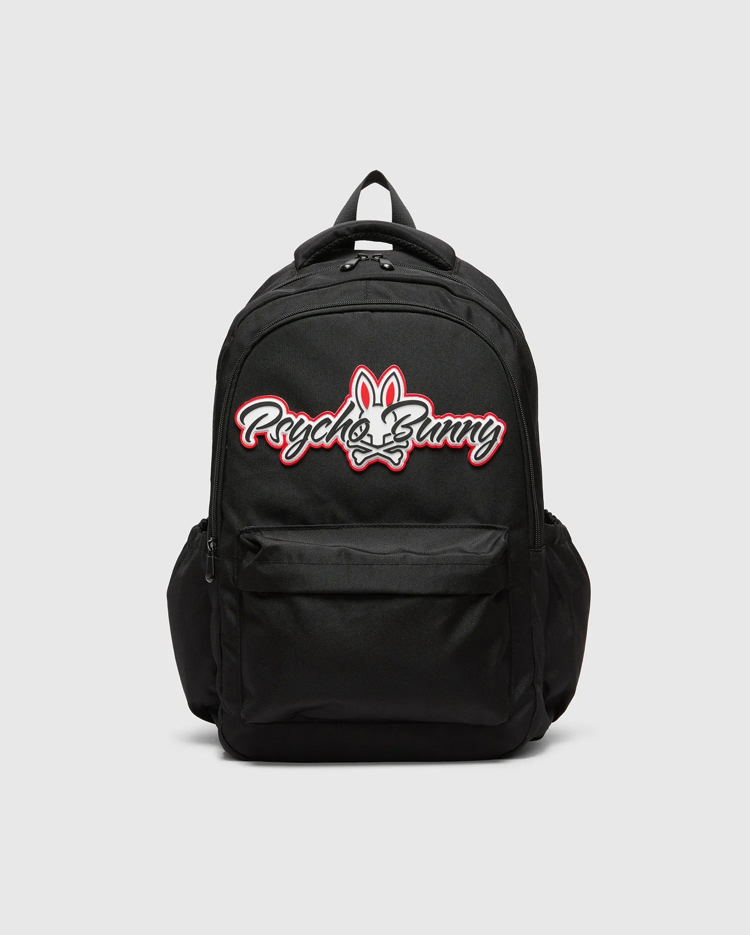 Black KIDS PAL BACKPACK with a large, centered white and red Psycho Bunny skull logo, featuring a front zip pocket and side pockets, made from durable woven fabric.