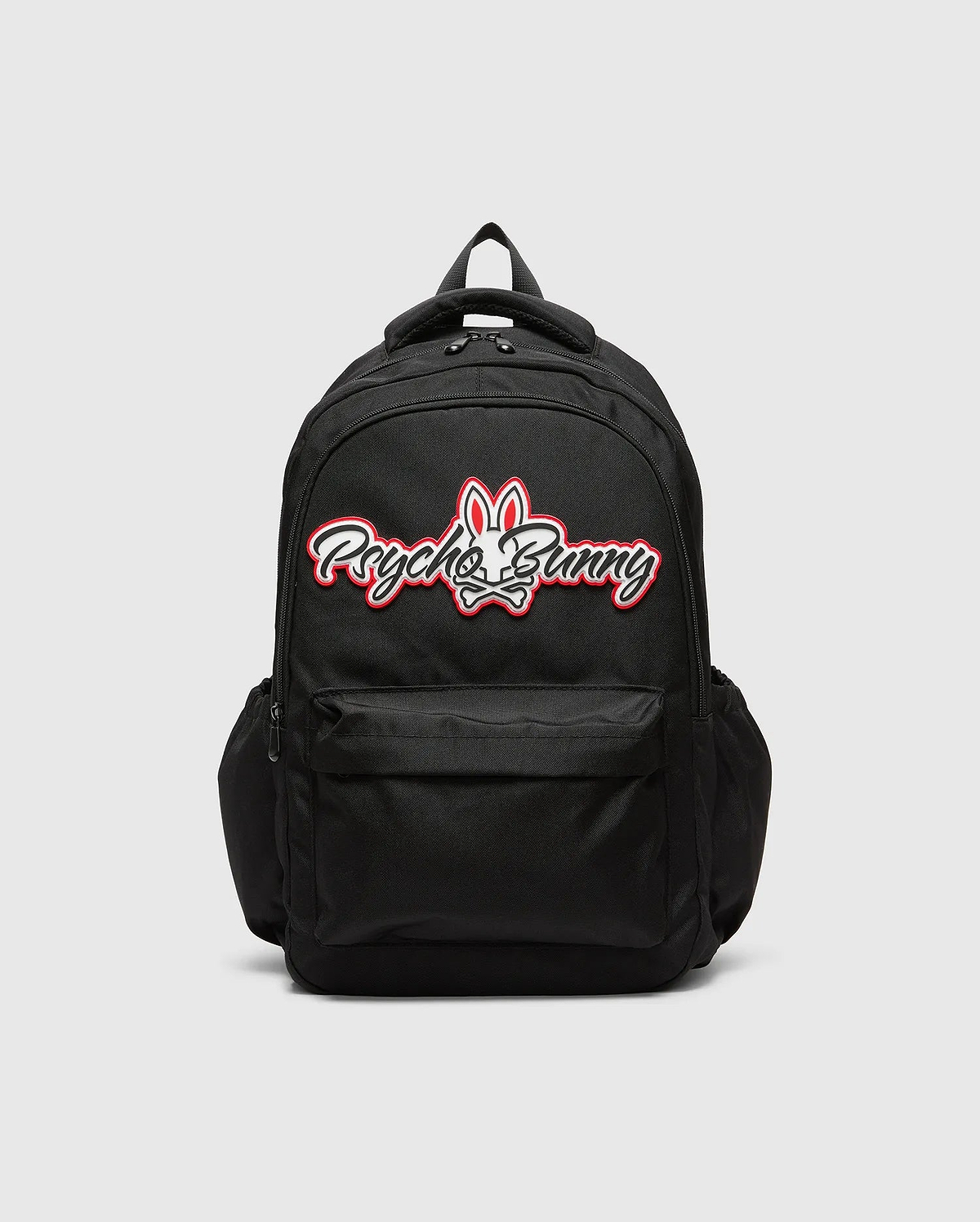 Black KIDS PAL BACKPACK with a large, centered white and red Psycho Bunny skull logo, featuring a front zip pocket and side pockets, made from durable woven fabric.