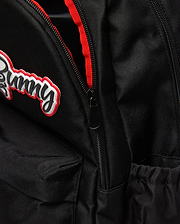 Black Kids Pal Backpack of durable woven fabric, featuring a raised black script Bunny logo with white and red outlines, a black zipper with red lining, and an elasticated side pocket.