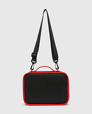Kids Pal Lunch Box, sleek black durable fabric with vibrant red piping, a sturdy top handle, and an adjustable black shoulder strap featuring red carabiner clips.