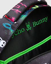Kids Quintin Backpack in black with vibrant neon pink, blue, green, and white splatter bunny skull graphics, featuring a bright green Psycho Bunny logo and trim on the interior.