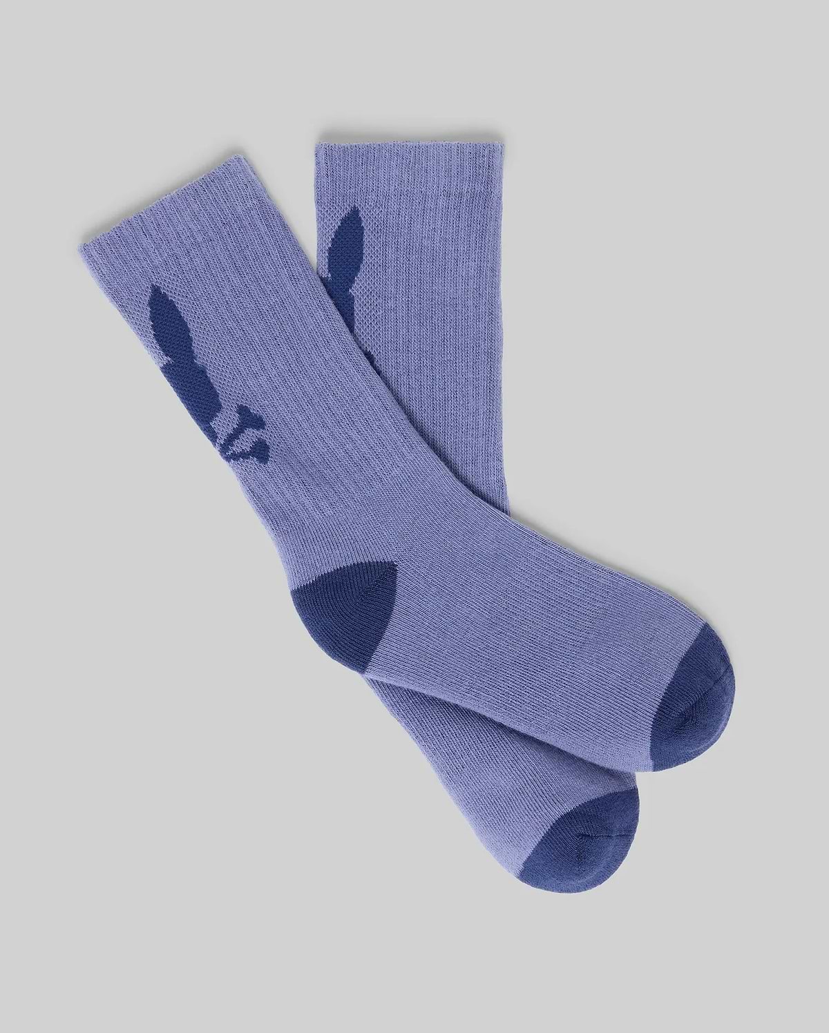 A pair from the KIDS 3 PACK SPORT SOCK - KO2200005 by Psycho Bunny in light purple cotton features dark blue heels, toes, and a bunny silhouette on each side. The socks are displayed flat on a light gray background.