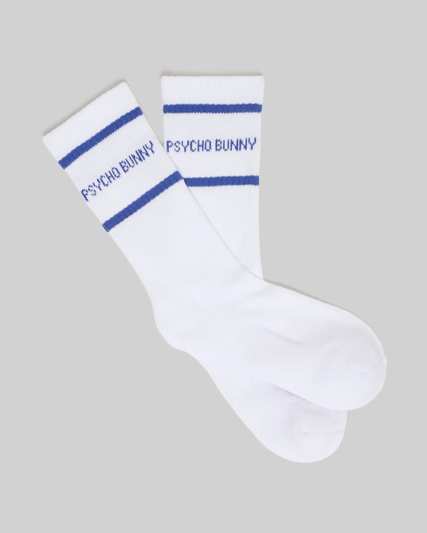 White Kids 3 Pack Sport Socks featuring two bold blue stripes and a prominent blue Psycho Bunny text logo knit into the ribbed crew cuff, highlighting premium knit fabric.