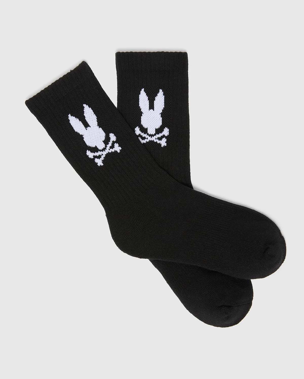 Kids 3 Pack Sport Socks, black knit with a comfortable ribbed cuff, prominently featuring the large white Psycho Bunny skull and crossbones logo on each ankle.