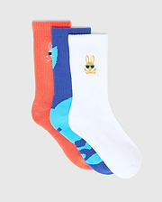 Kids Sunny 3 Pack Sport Socks: a coral ribbed knit, a royal blue and light blue patterned knit, and a white knit sock. Each features a small embroidered Psycho Bunny skull logo, the white one with blue sunglasses.