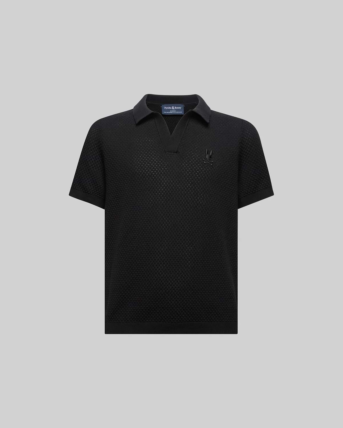 Kids Devon Knit Polo, black textured knit with a V-neck collar, classic fit, and a small tonal embroidered Psycho Bunny skull logo on the left chest.