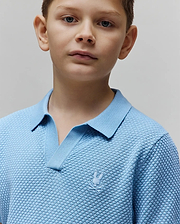 Kids Devon Bubble Stitch Knit Polo in light blue, featuring a textured bubble knit fabric, open V-neck collar, and a small, tone-on-tone embroidered Psycho Bunny skull logo on the left chest.