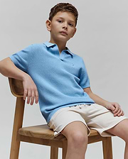 Kids Devon Bubble Stitch Knit Polo in light blue, featuring a textured bubble stitch knit fabric, classic fit, and a small embroidered Psycho Bunny skull logo on the left chest.