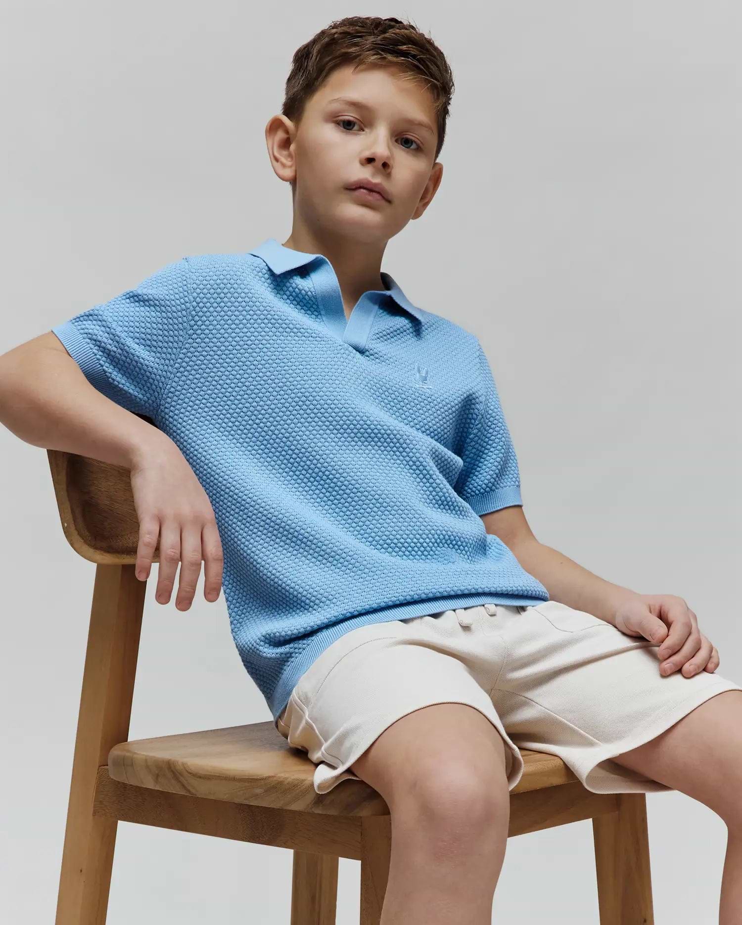 Kids Devon Bubble Stitch Knit Polo in light blue, featuring a textured bubble stitch knit fabric, classic fit, and a small embroidered Psycho Bunny skull logo on the left chest.
