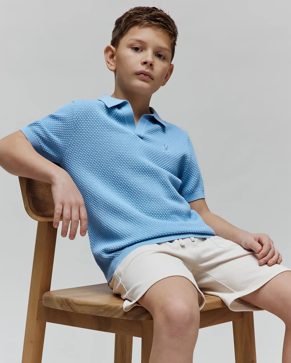 Kids Devon Bubble Stitch Knit Polo in light blue, featuring a textured bubble stitch knit fabric, classic fit, and a small embroidered Psycho Bunny skull logo on the left chest.