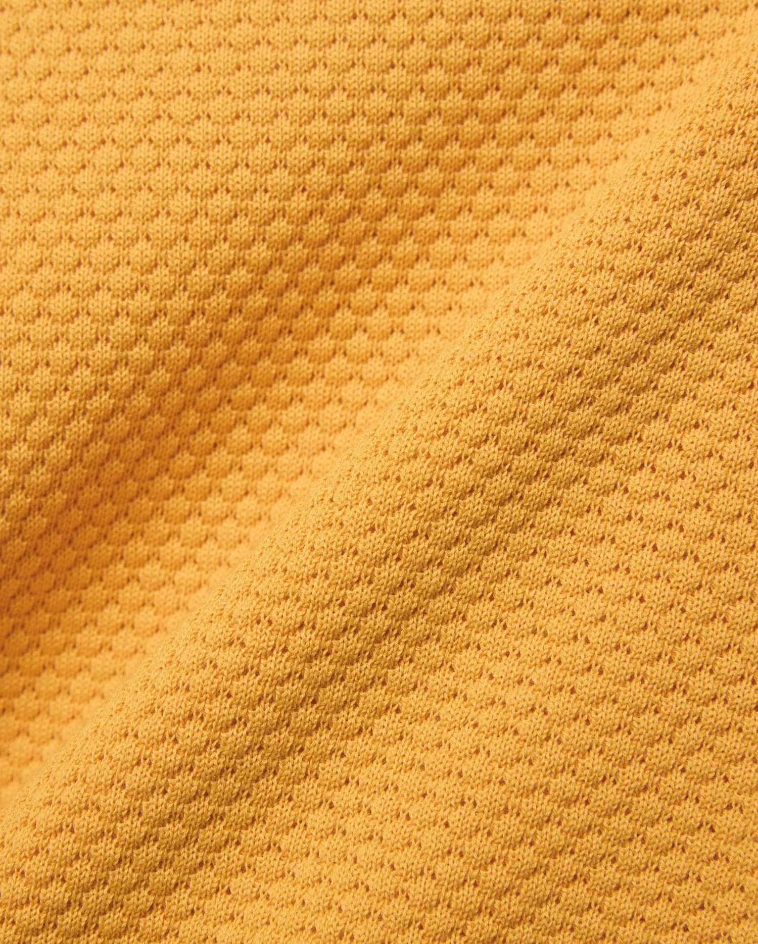 Kids Devon Knit Polo in bold golden-yellow, crafted from a premium, refined knit fabric featuring a distinctive micro-waffle texture, perfect for elevated streetwear style.