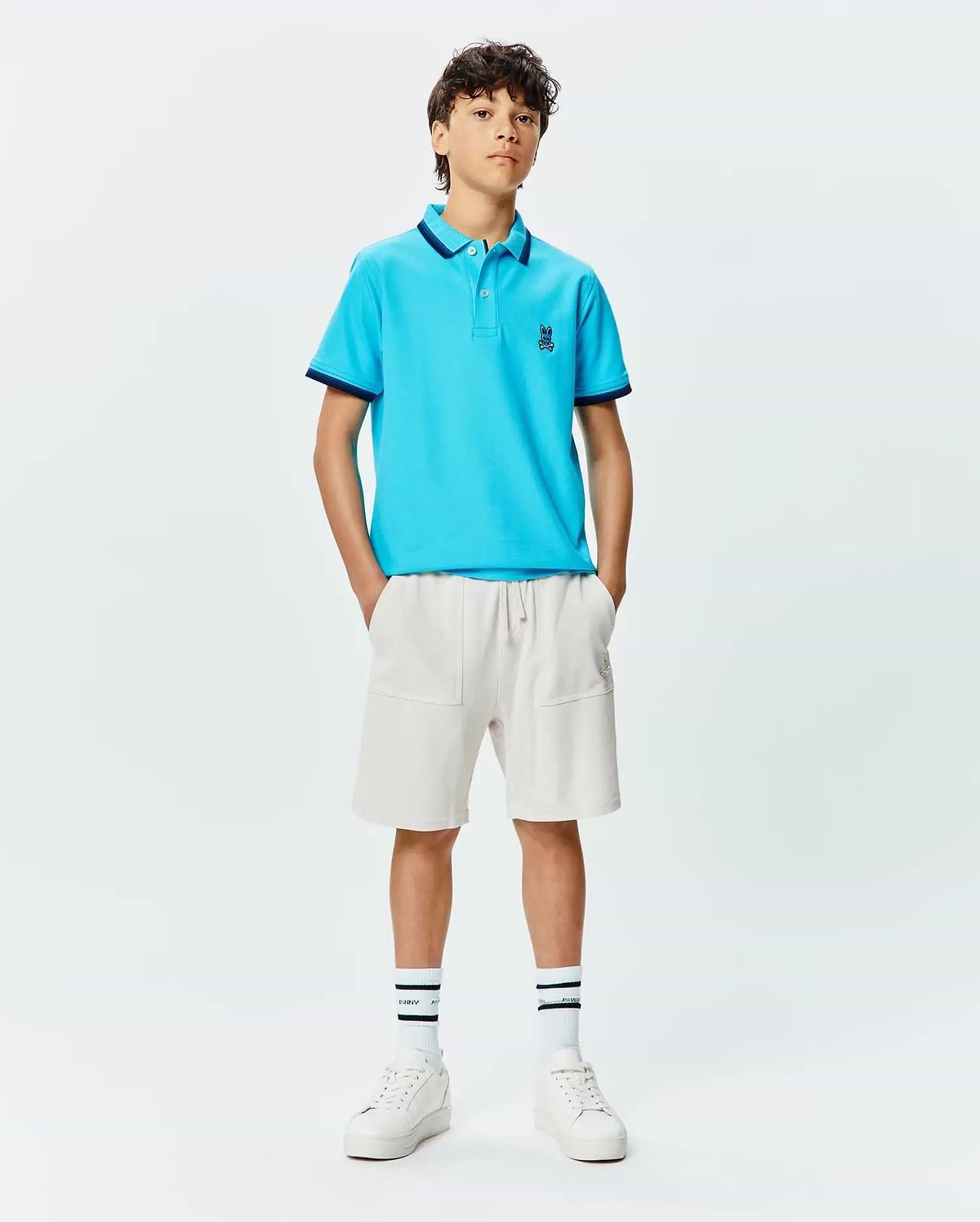 Kids Holden Pique Polo in bright blue, featuring a classic fit, pique texture, navy tipped collar and cuffs, and a small embroidered Psycho Bunny skull logo on the left chest.