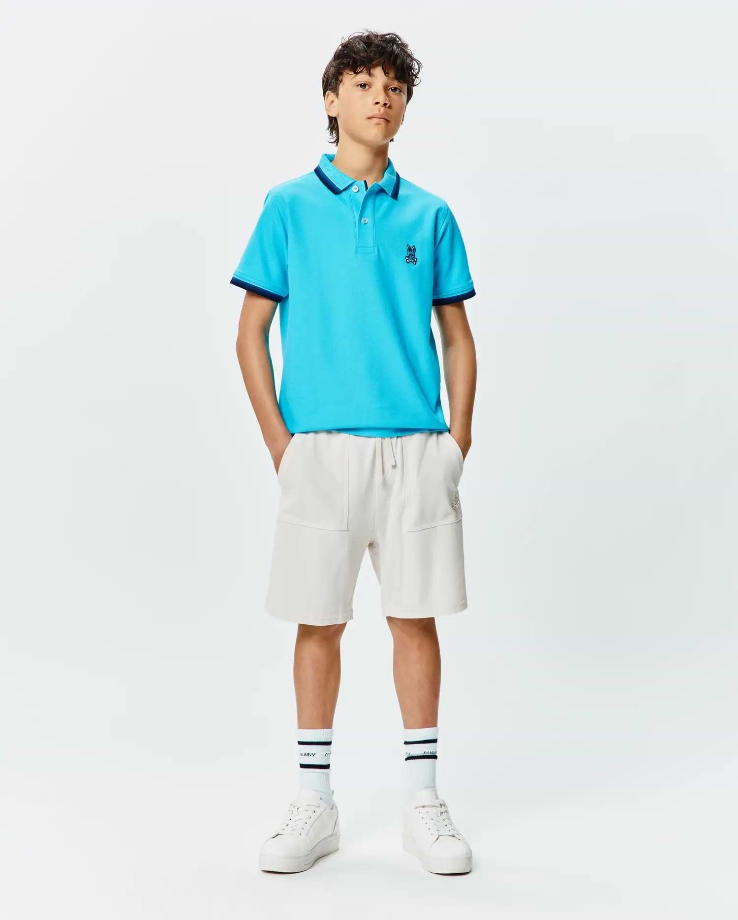 Kids Holden Pique Polo in bright blue, featuring a classic fit, pique texture, navy tipped collar and cuffs, and a small embroidered Psycho Bunny skull logo on the left chest.