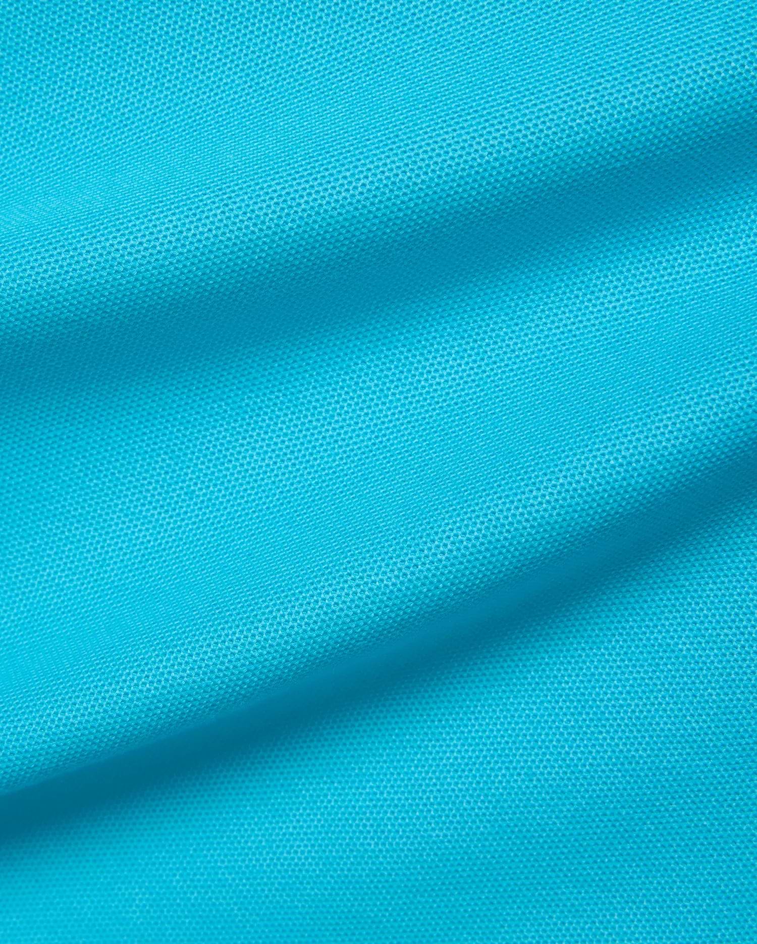 Kids Holden Pique Polo in vibrant aqua blue, crafted from breathable pique knit fabric, featuring the iconic small embroidered Psycho Bunny skull logo on the chest.