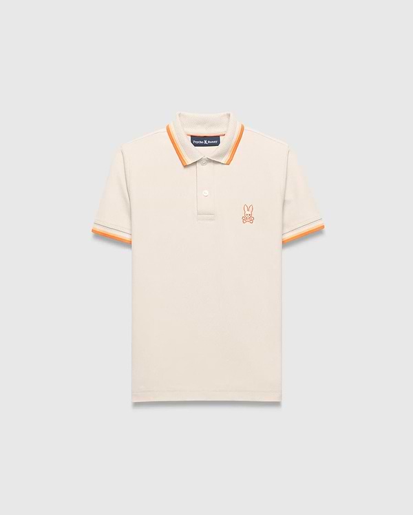 Kids Holden Pique Polo, a classic fit cream pique polo with orange striped ribbed collar and cuffs, featuring a small embroidered orange Psycho Bunny skull logo on the left chest.