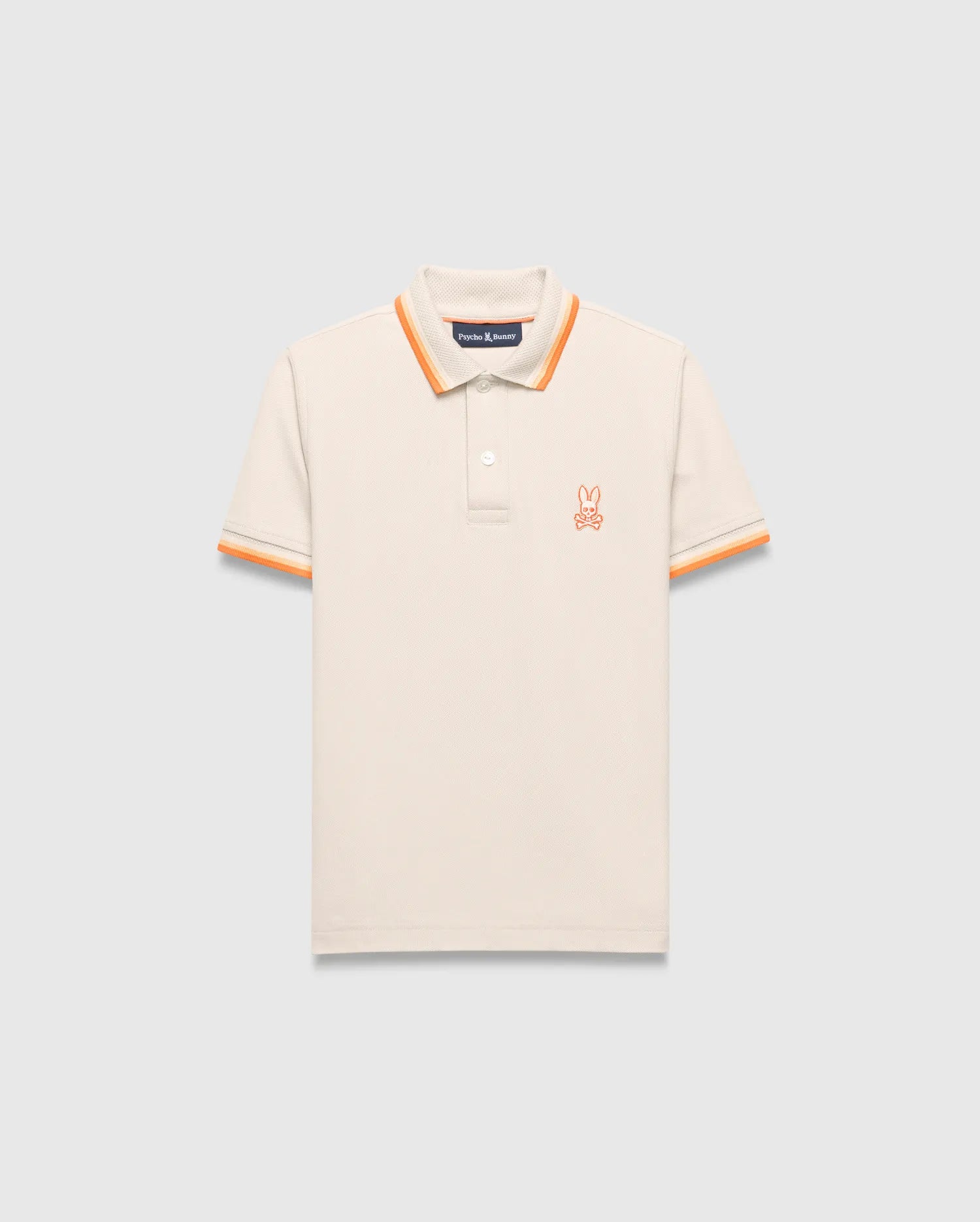 Kids Holden Pique Polo, a classic fit cream pique polo with orange striped ribbed collar and cuffs, featuring a small embroidered orange Psycho Bunny skull logo on the left chest.