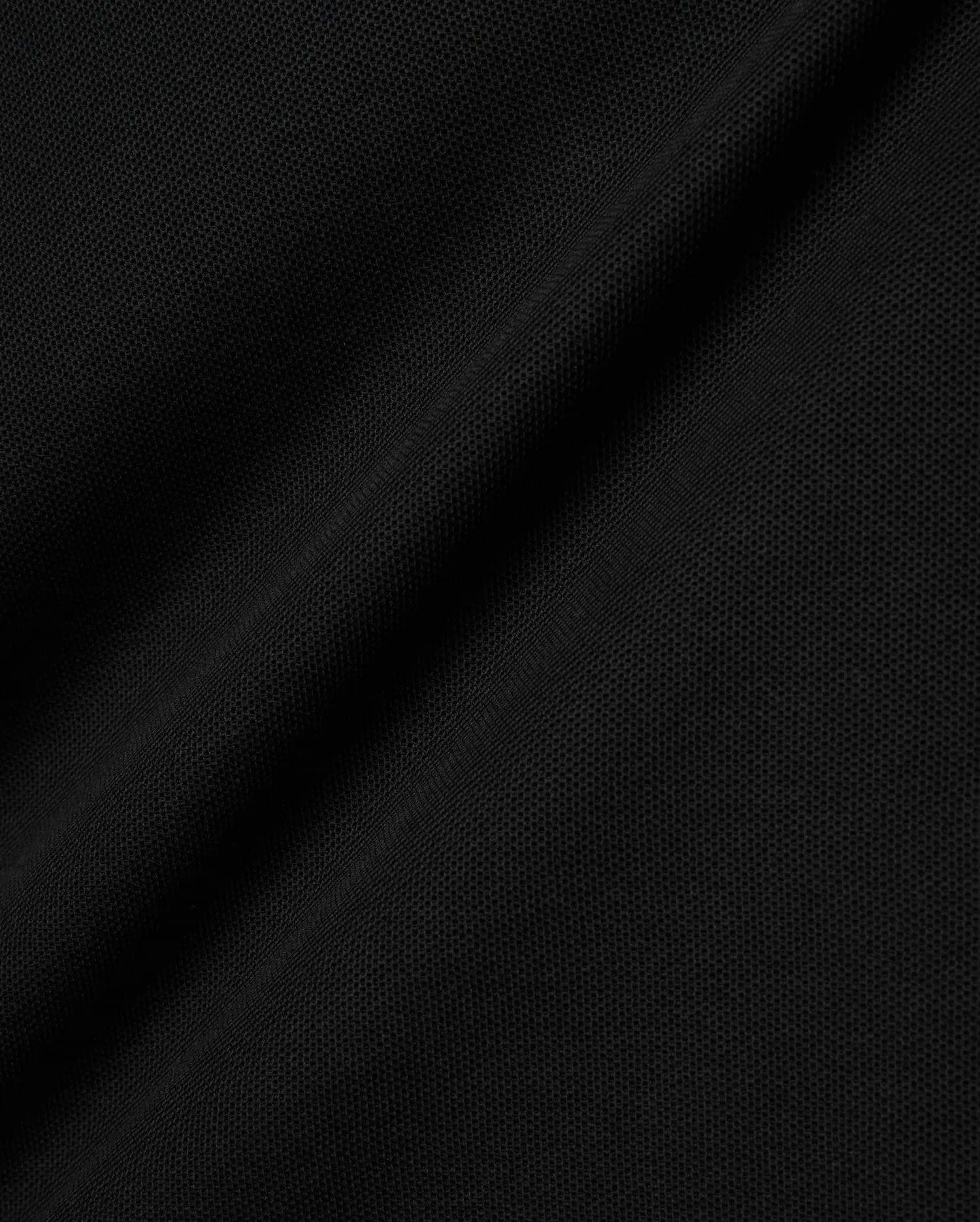 Black Kids Brad Pique Polo fabric, a close-up revealing the refined, breathable textured pique weave with subtle, elegant folds, perfect for premium Psycho Bunny menswear. (6)