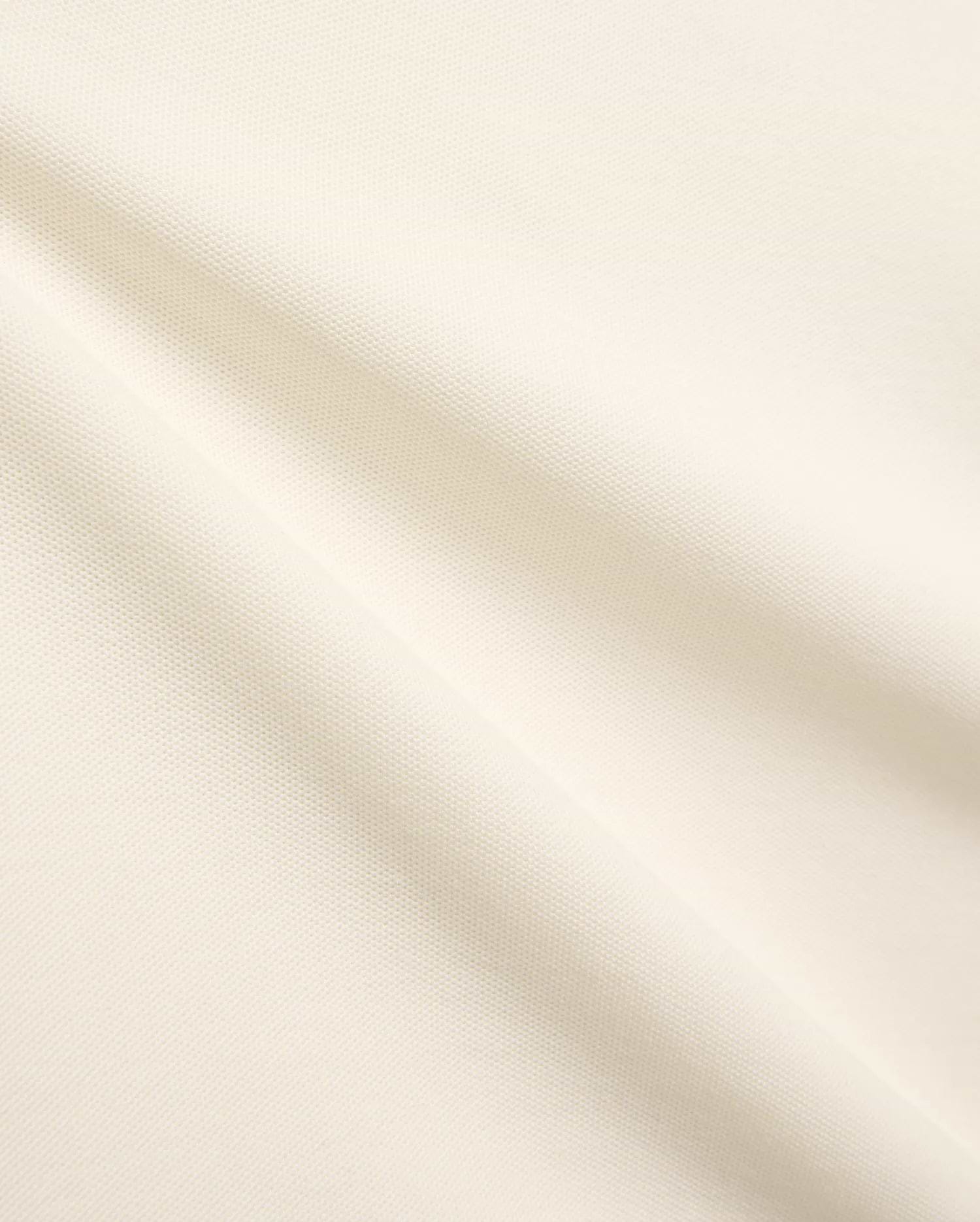 Kids Sunny Pique Polo, a creamy off-white shirt crafted from textured pique fabric, featuring the signature small embroidered Psycho Bunny skull logo on the left chest.
