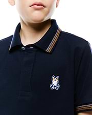 Kids Jaydon Pique Polo in navy, classic fit, pique texture. Features small embroidered multi-color Psycho Bunny skull logo on left chest, with orange and white striped collar and cuffs.