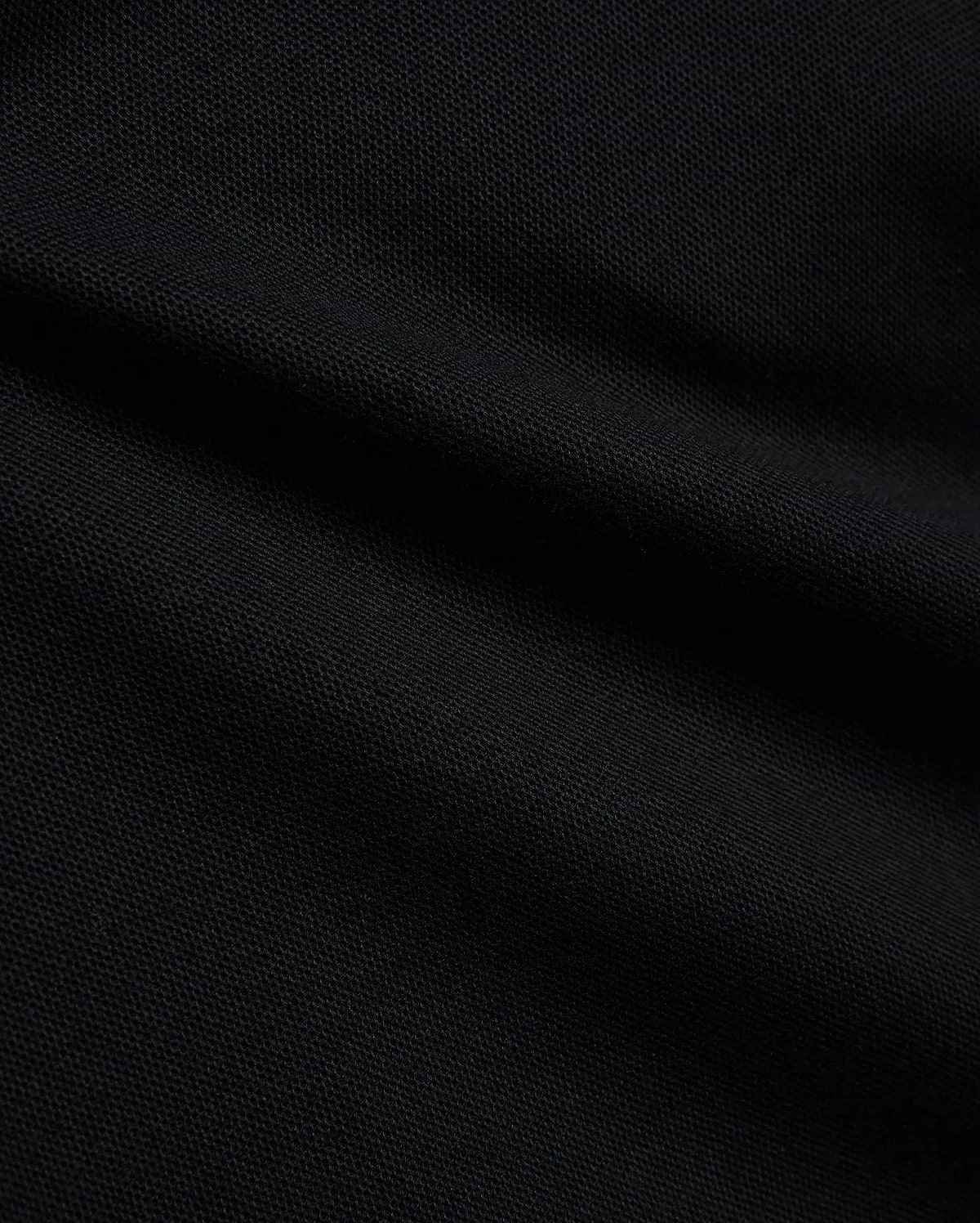Psycho Bunny Kids Stan Pique Polo in deep black, showcasing the premium, breathable pique knit fabric with a subtle texture, perfect for refined streetwear.