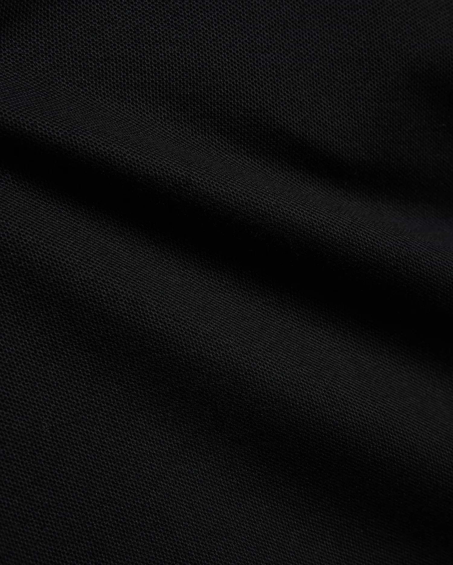 Psycho Bunny Kids Stan Pique Polo in deep black, showcasing the premium, breathable pique knit fabric with a subtle texture, perfect for refined streetwear.