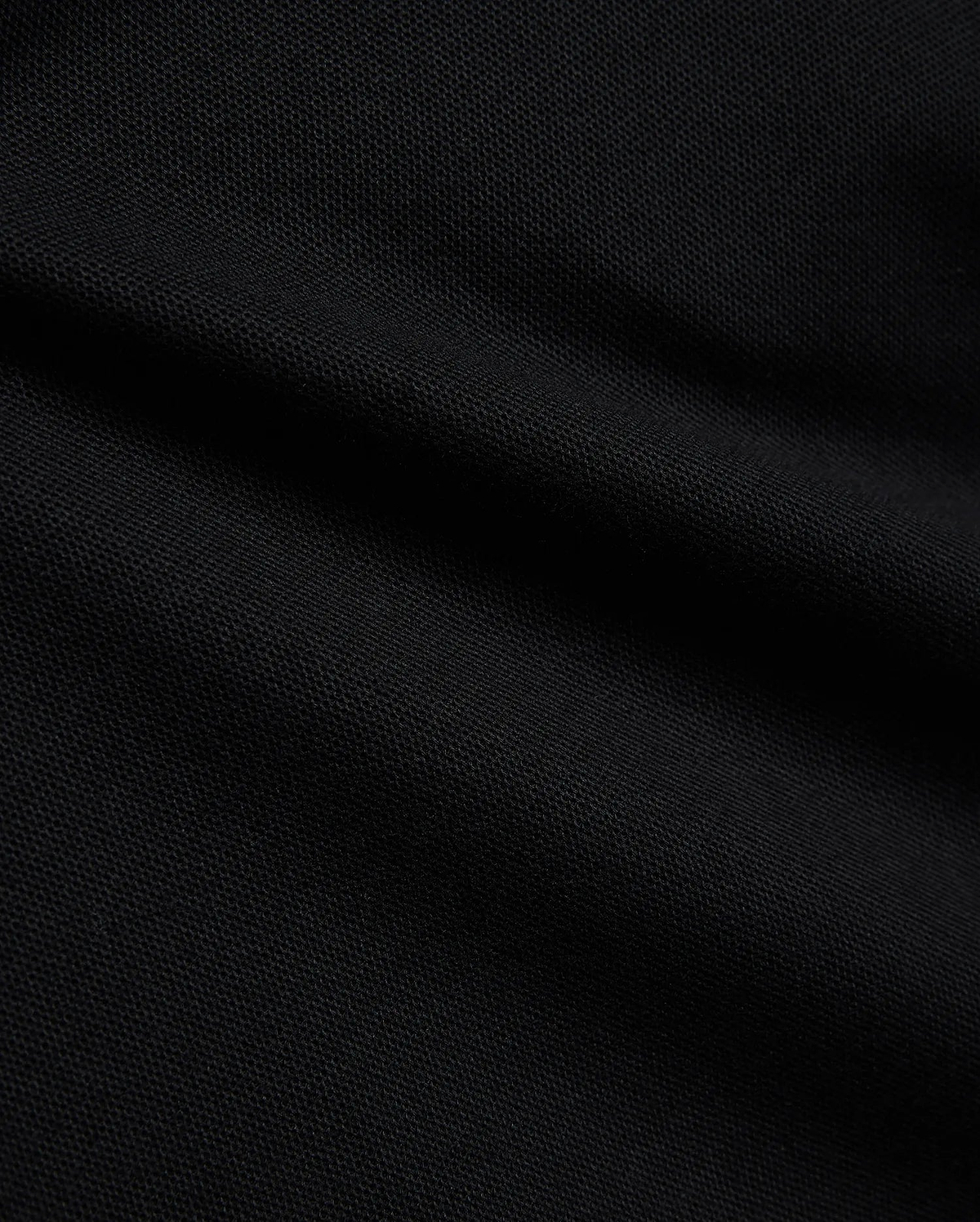 Psycho Bunny Kids Stan Pique Polo in deep black, showcasing the premium, breathable pique knit fabric with a subtle texture, perfect for refined streetwear.