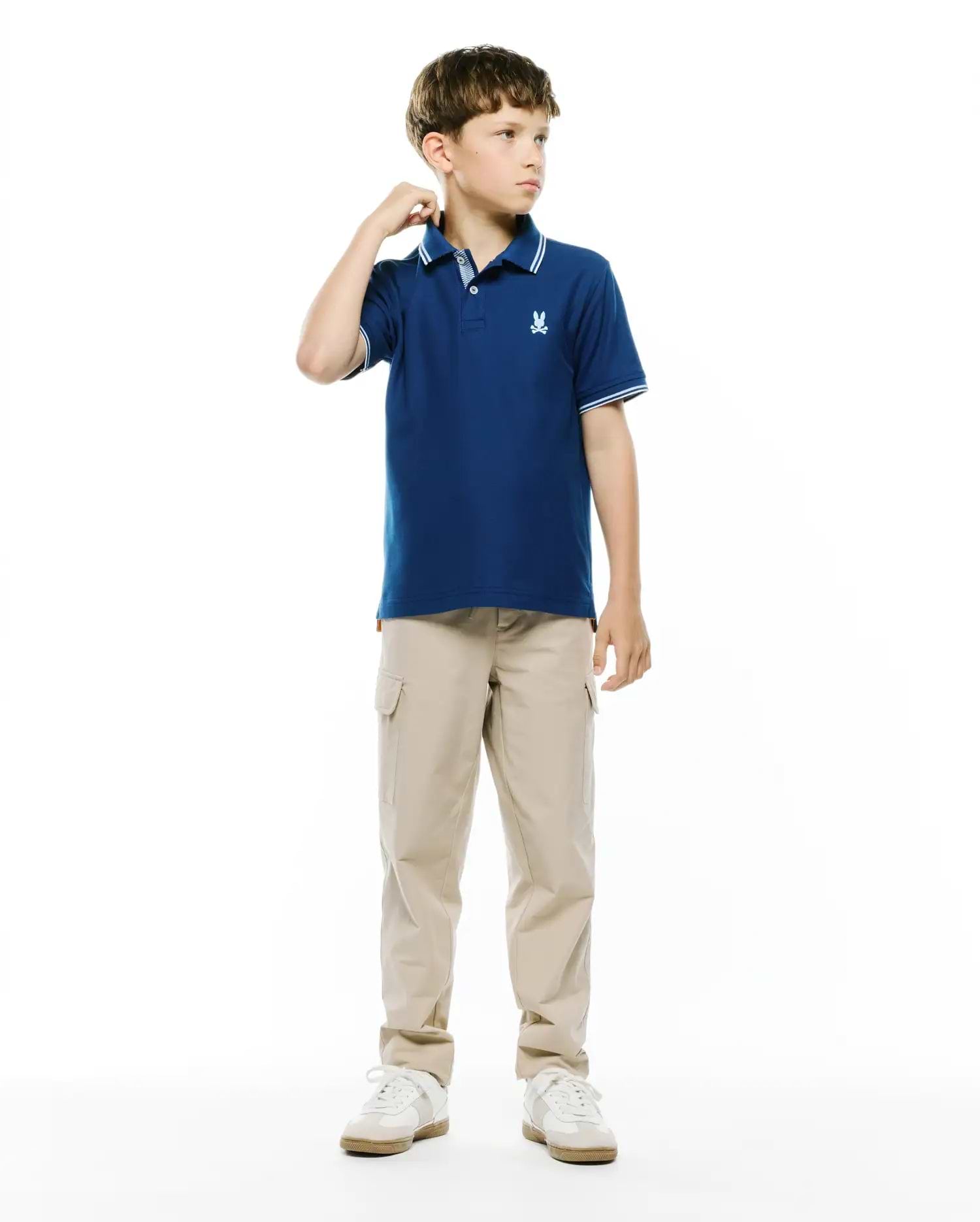 Kids Stan Pique Polo in navy blue, featuring a classic fit, pique knit fabric, ribbed collar and cuffs with white double stripes, and a small embroidered white Psycho Bunny skull logo on the left chest.