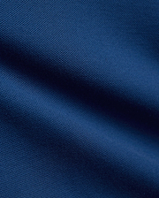 Kids Stan Pique Polo in a rich, dark navy blue, showcasing the classic, breathable textured pique knit fabric with subtle, elegant folds and shadows across its surface.