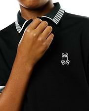 Kids Timmy Pique Polo, a black classic fit pique polo shirt with a ribbed collar and cuffs featuring crisp white stripes, accented by a small, embroidered white Psycho Bunny skull logo on the left chest.