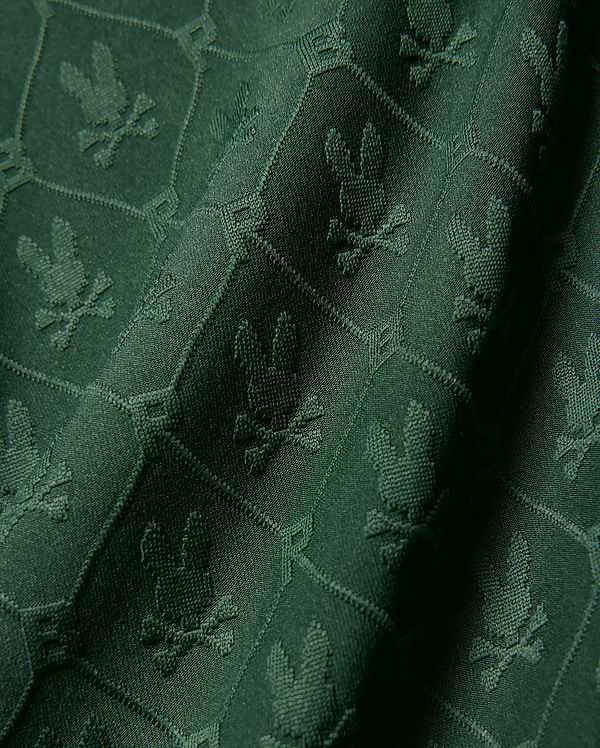 Kids Garry Jacquard Johnny Collar Polo in deep green, featuring an all-over tonal jacquard knit pattern of the iconic Psycho Bunny skull logo within a subtle geometric grid. (6)