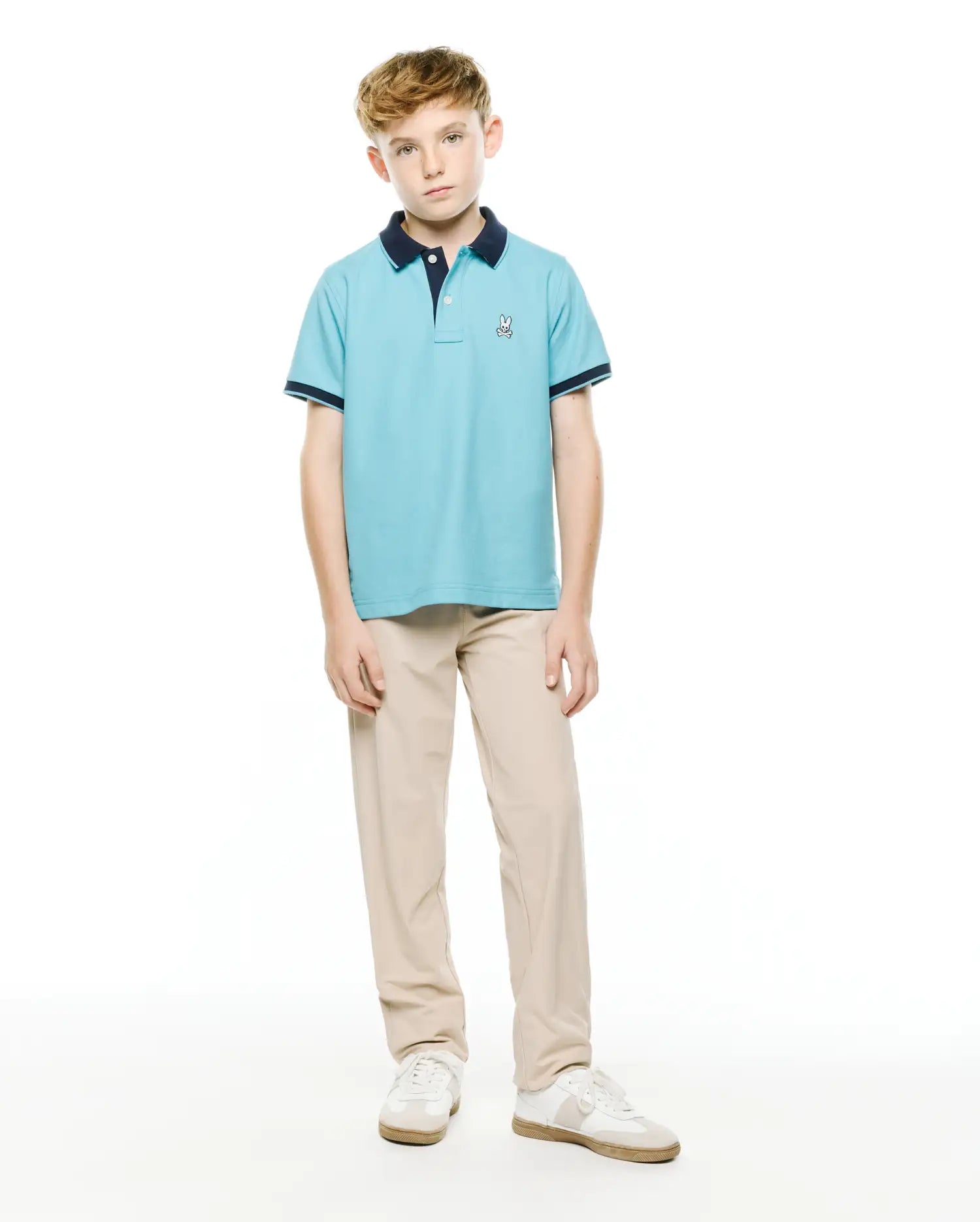 Kids' Klaus Pique Polo, a light blue classic fit pique knit polo with navy collar and sleeve cuffs, featuring a small embroidered Psycho Bunny logo on the left chest. (4)