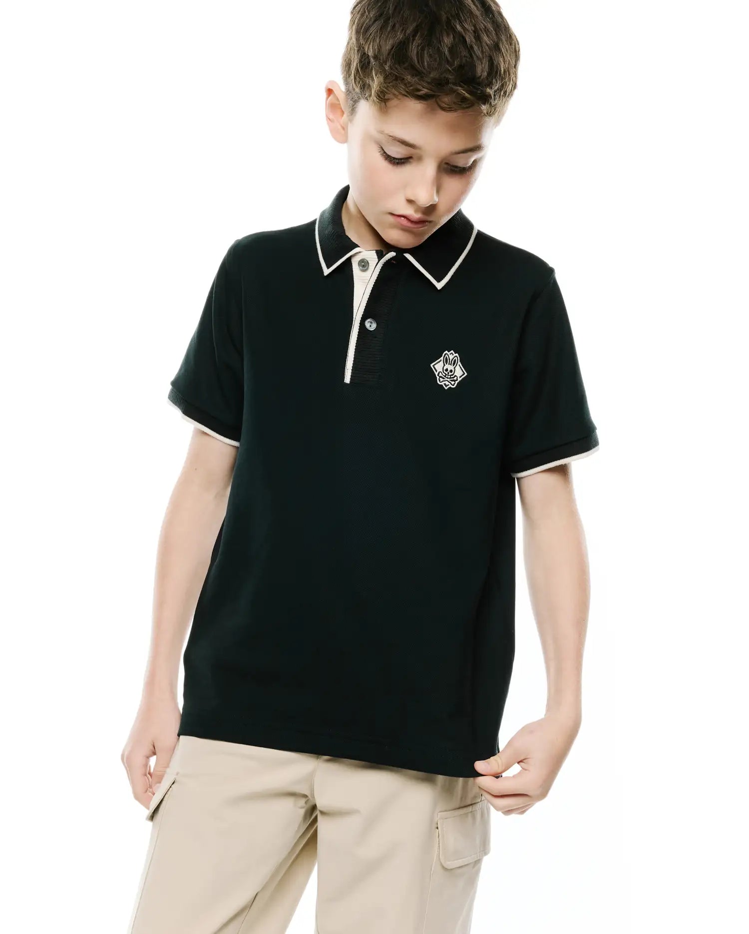Kids Robin Pique Polo in deep green, featuring a classic fit, pique knit fabric, cream-tipped collar and cuffs, and a small white embroidered Psycho Bunny skull logo on the left chest.