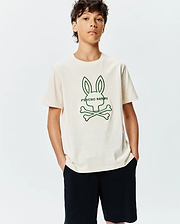Kids Craig Graphic Tee in cream jersey, featuring a large central green outline of the iconic Psycho Bunny skull and crossbones logo with PSYCHO BUNNY text, in a classic fit.