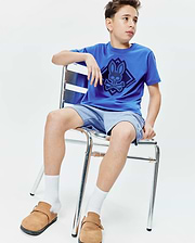 Kids Tobias Graphic Tee, a royal blue jersey t-shirt with a large central navy Psycho Bunny skull and crossbones diamond graphic, and light blue knit shorts with a small embroidered bunny logo.