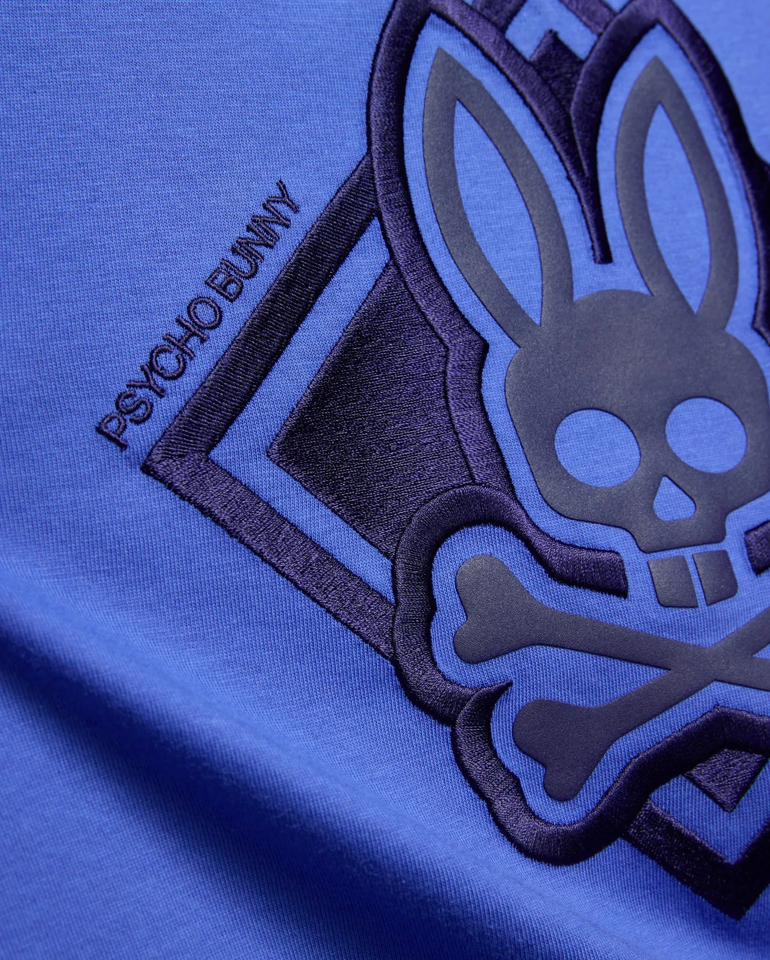Kids Tobias Graphic Tee in vibrant blue jersey knit, featuring a large dark navy embroidered and raised Psycho Bunny skull logo with PSYCHO BUNNY text.