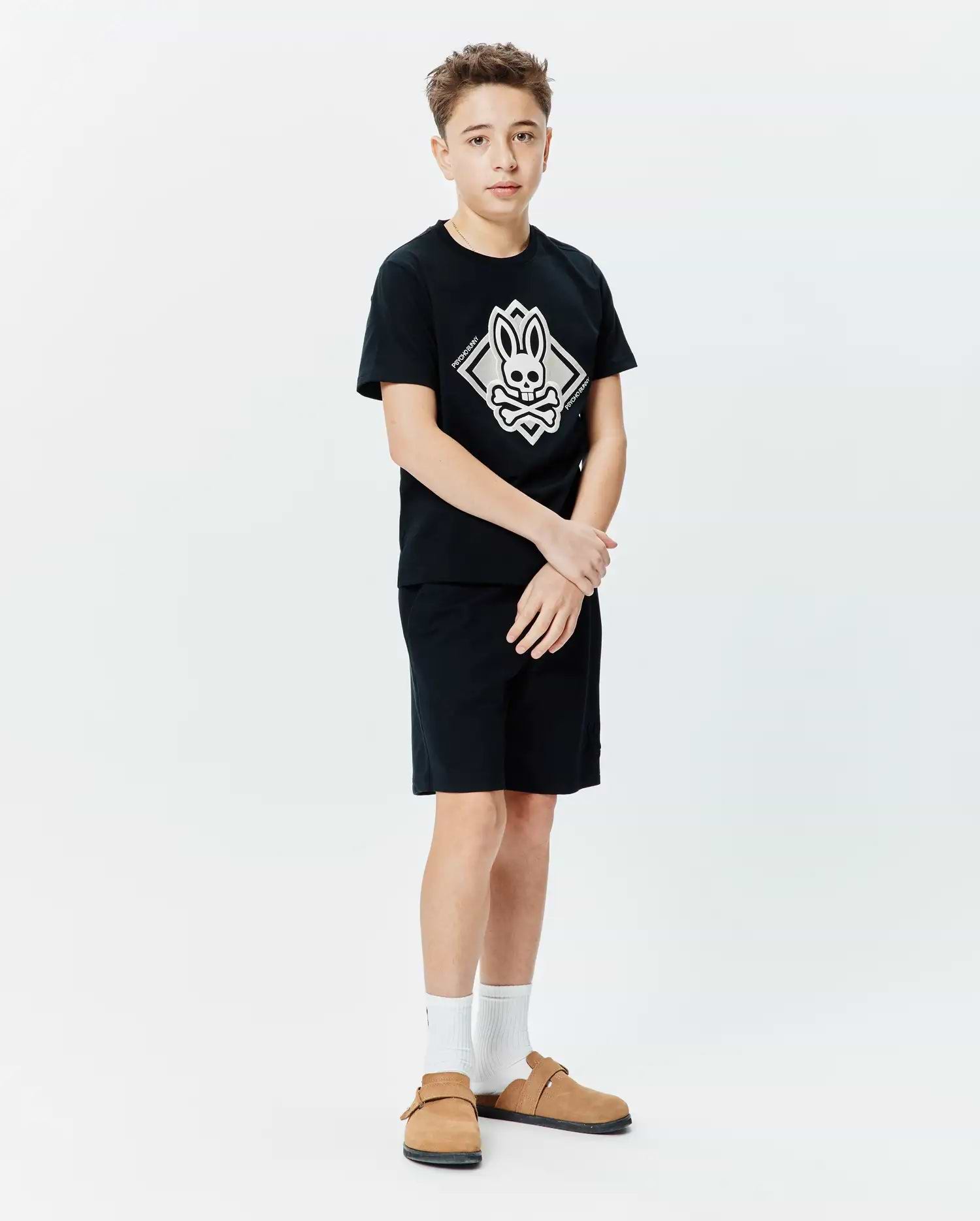 Kids Tobias Graphic Tee, black jersey knit, classic fit, featuring a large central white and grey Psycho Bunny skull and crossbones diamond graphic with vertical brand name.