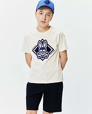 Kids Tobias Graphic Tee, a classic fit cream jersey t-shirt with a large central dark blue Psycho Bunny skull and crossbones logo graphic in a diamond shape.