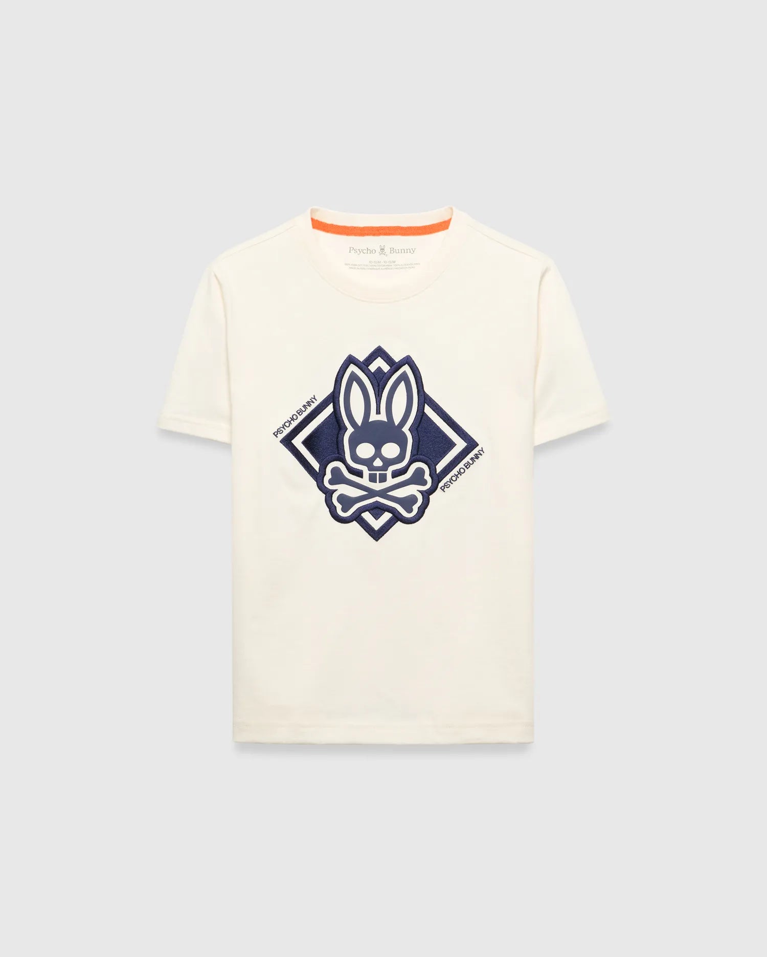 Kids Tobias Graphic Tee, a classic fit cream jersey t-shirt with a large, textured navy blue Psycho Bunny skull and crossbones logo graphic inside a diamond on the chest, featuring orange neckline trim.