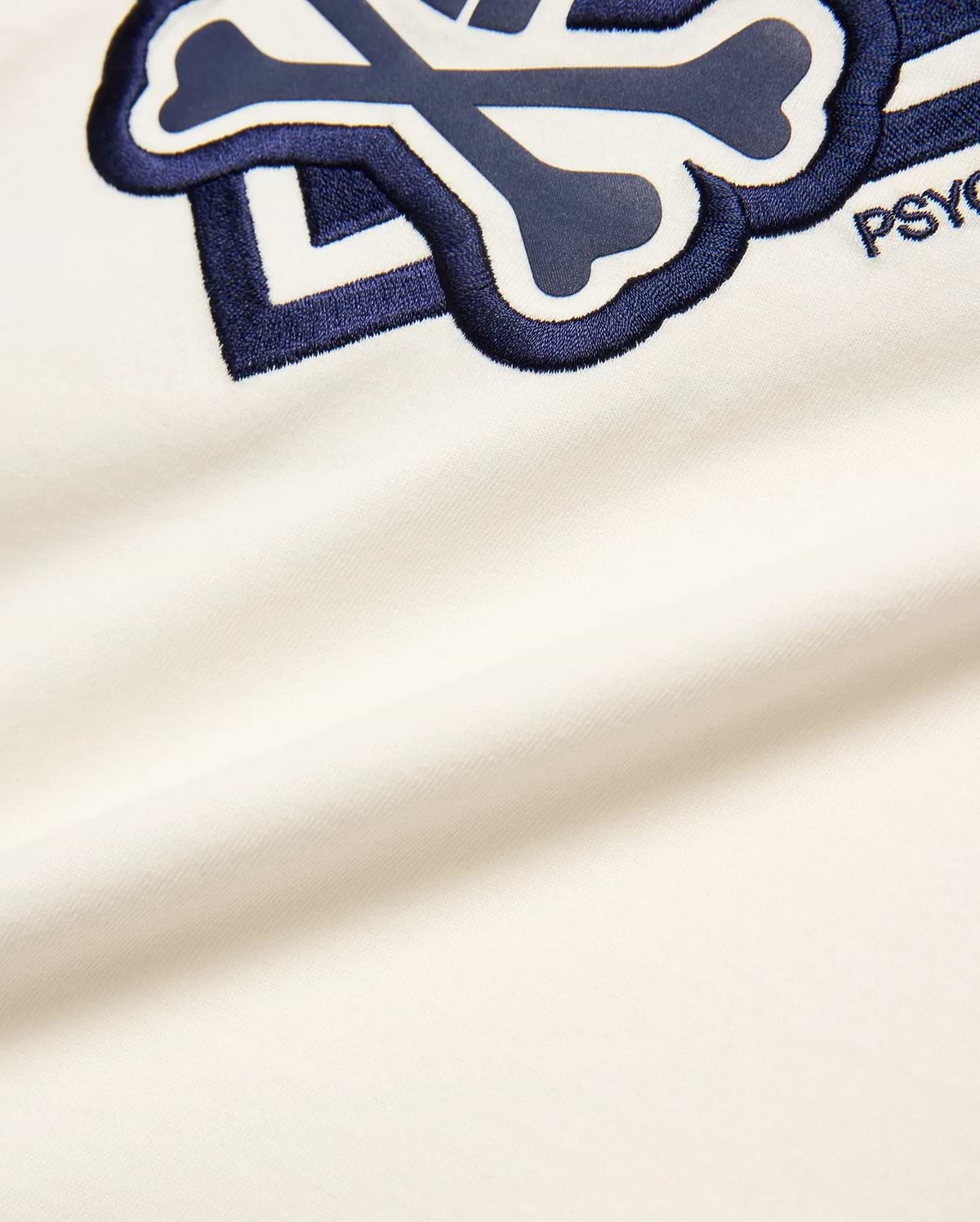 Off-white Kids Tobias Graphic Tee, soft jersey knit, featuring a large, central embroidered navy and white Psycho Bunny skull and crossbones logo with PSYCHO text.